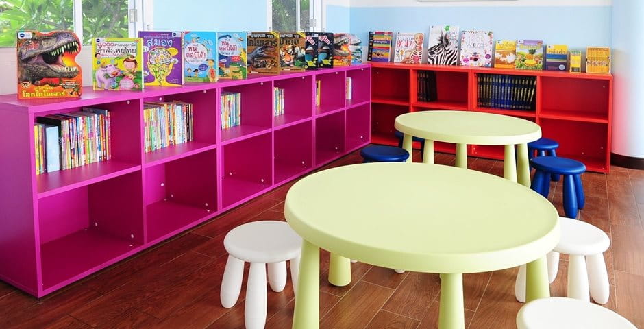 Bibliothek mit bunten Stühlen, Tischen und Kinderbüchern