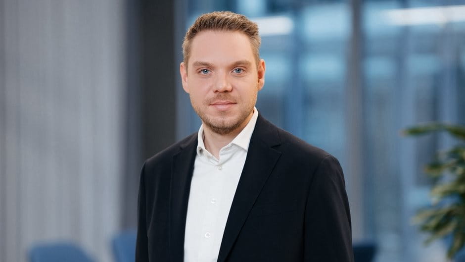 Mann in Anzug vor verschwommenem Hintergrund.