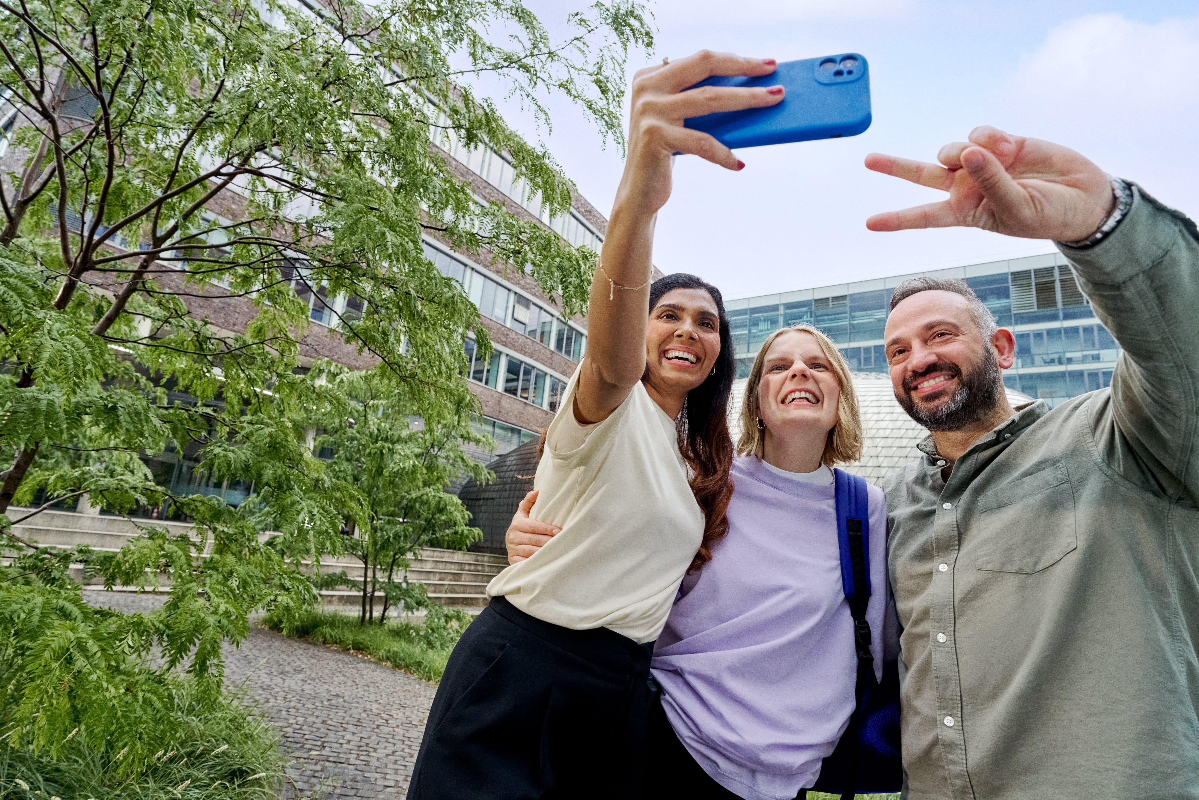 Beiersdorf Kolleginnen und Kollegen machen gemeinsam ein Selfie auf dem Campus und zeigen Teamgeist, Zusammenarbeit und eine inklusive Unternehmenskultur.