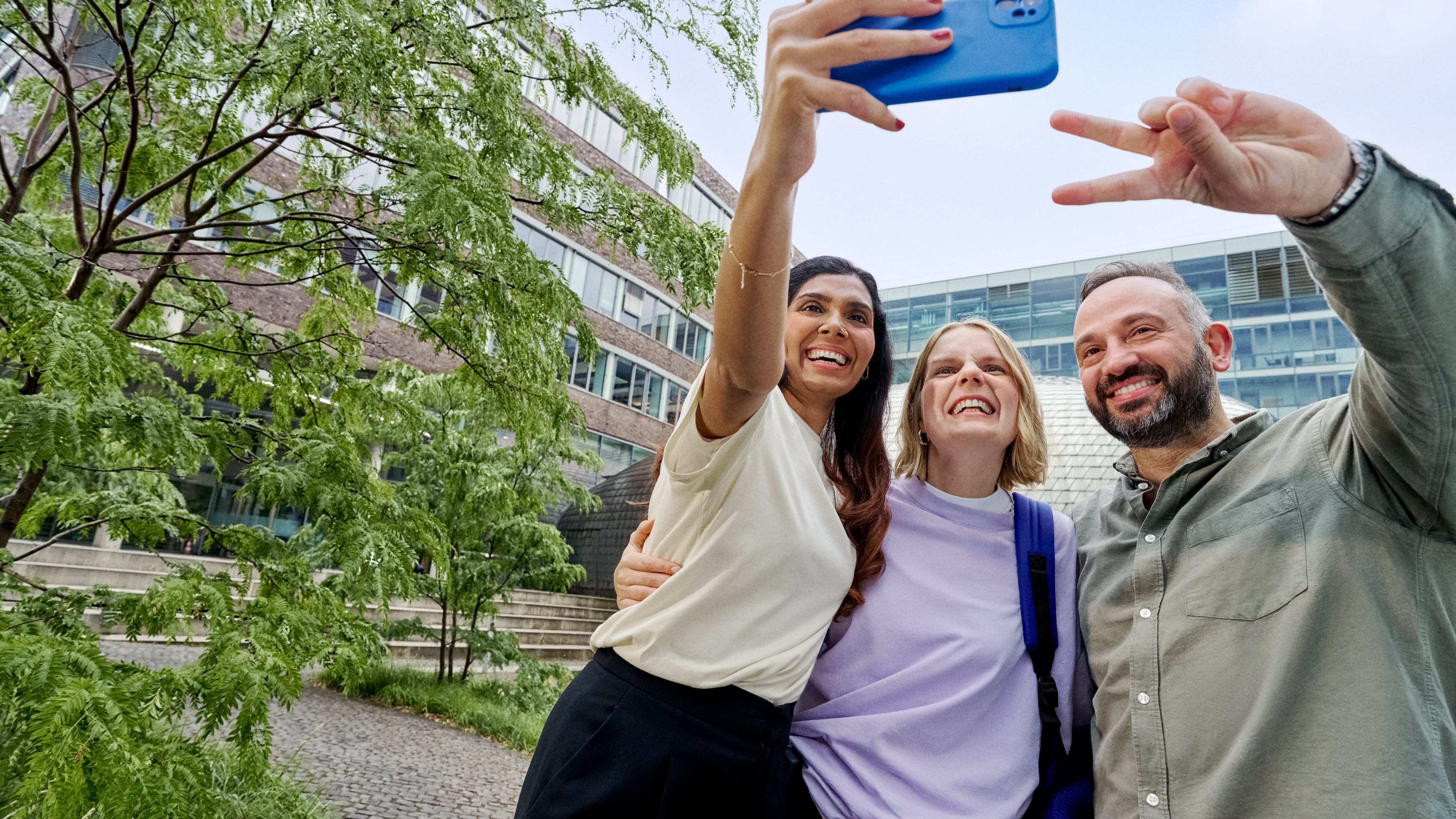 Beiersdorf Kolleginnen und Kollegen machen gemeinsam ein Selfie auf dem Campus und zeigen Teamgeist, Zusammenarbeit und eine inklusive Unternehmenskultur.