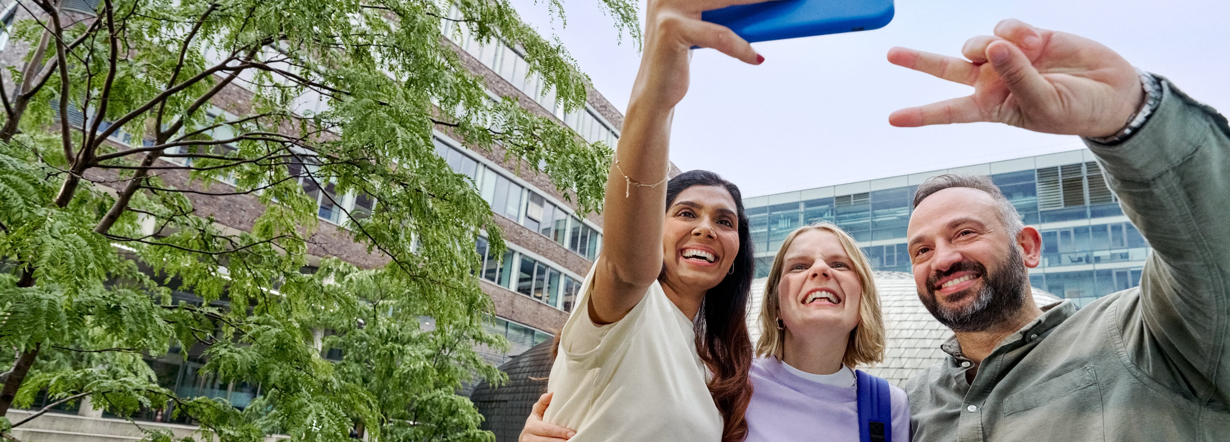 Beiersdorf Kolleginnen und Kollegen machen gemeinsam ein Selfie auf dem Campus und zeigen Teamgeist, Zusammenarbeit und eine inklusive Unternehmenskultur.