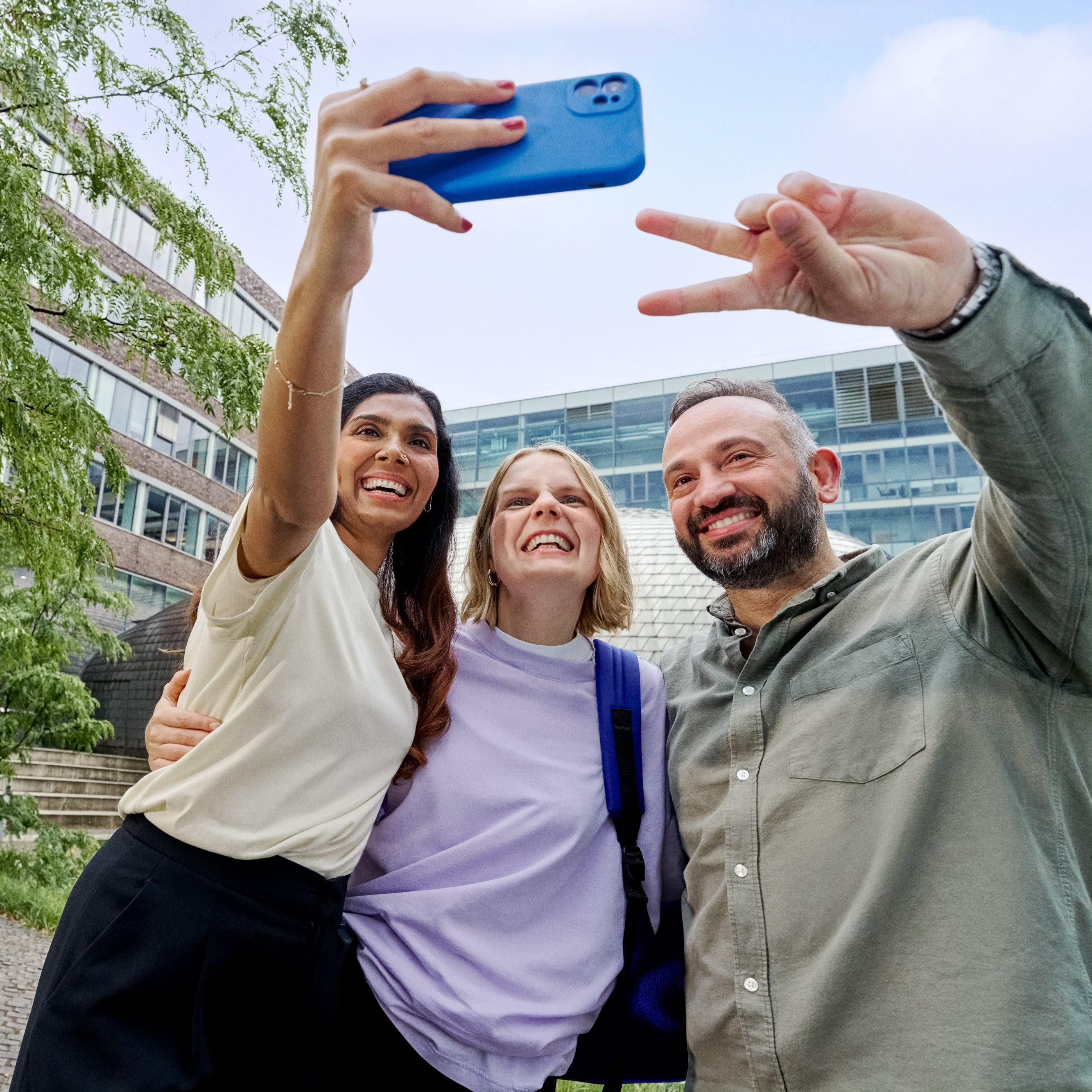 Beiersdorf Kolleginnen und Kollegen machen gemeinsam ein Selfie auf dem Campus und zeigen Teamgeist, Zusammenarbeit und eine inklusive Unternehmenskultur.