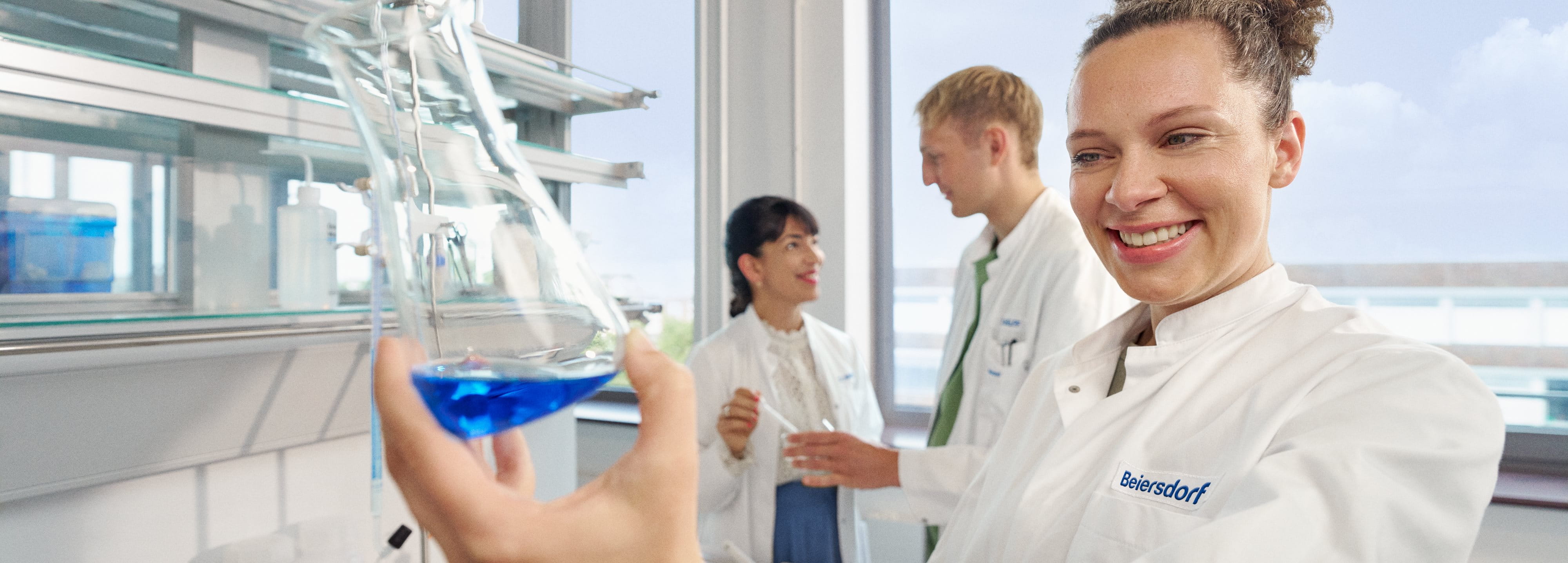Beiersdorf Forschende arbeiten in einem Labor zusammen und fördern Innovation sowie die Entwicklung von Hautpflege- und Consumer-Care-Lösungen.
