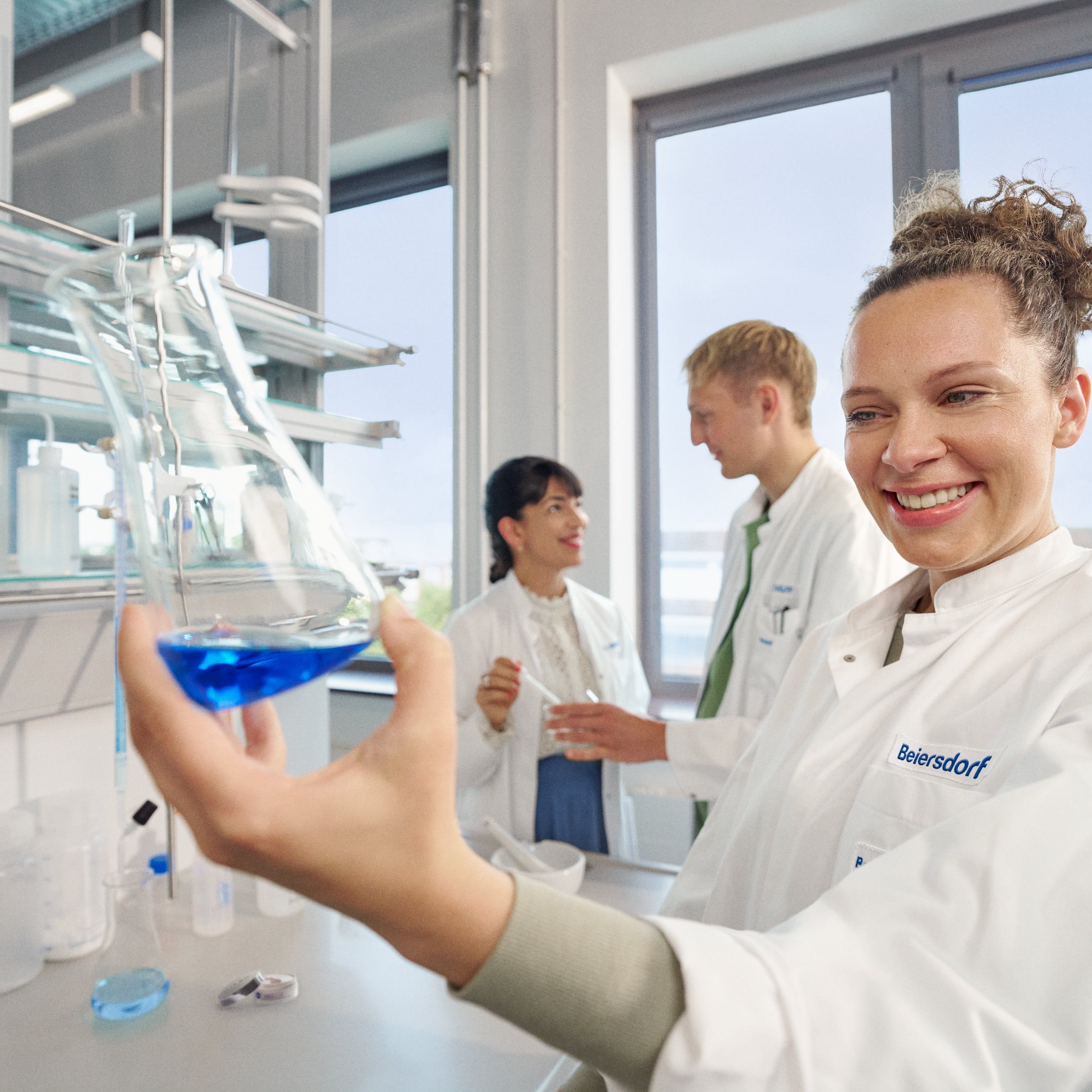 Beiersdorf Forschende arbeiten in einem Labor zusammen und fördern Innovation sowie die Entwicklung von Hautpflege- und Consumer-Care-Lösungen.