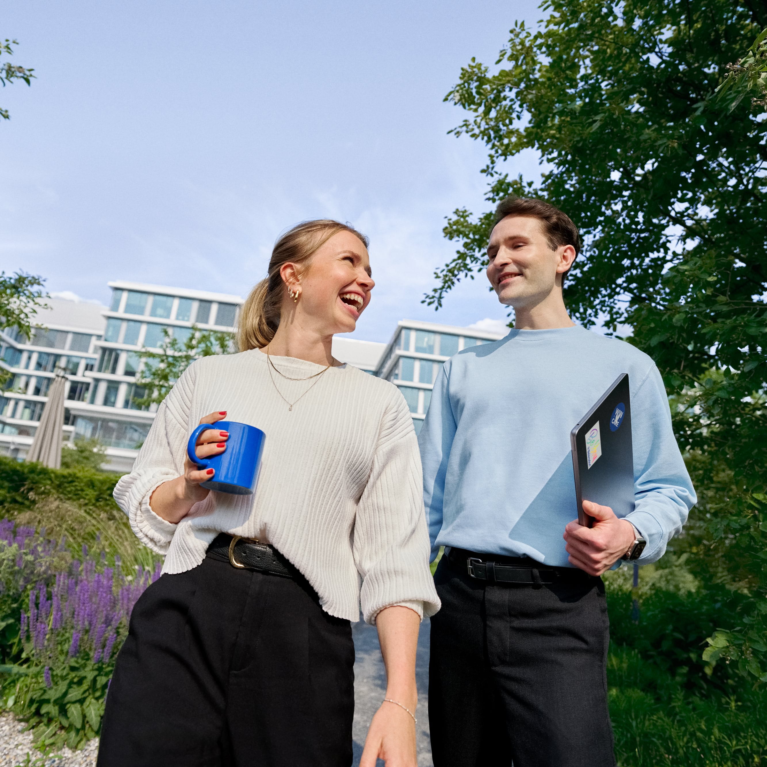 Beiersdorf Mitarbeitende tauschen sich bei einem Spaziergang auf dem Unternehmenscampus aus und stehen für Zusammenarbeit, Unternehmenskultur und flexible Arbeitsweisen