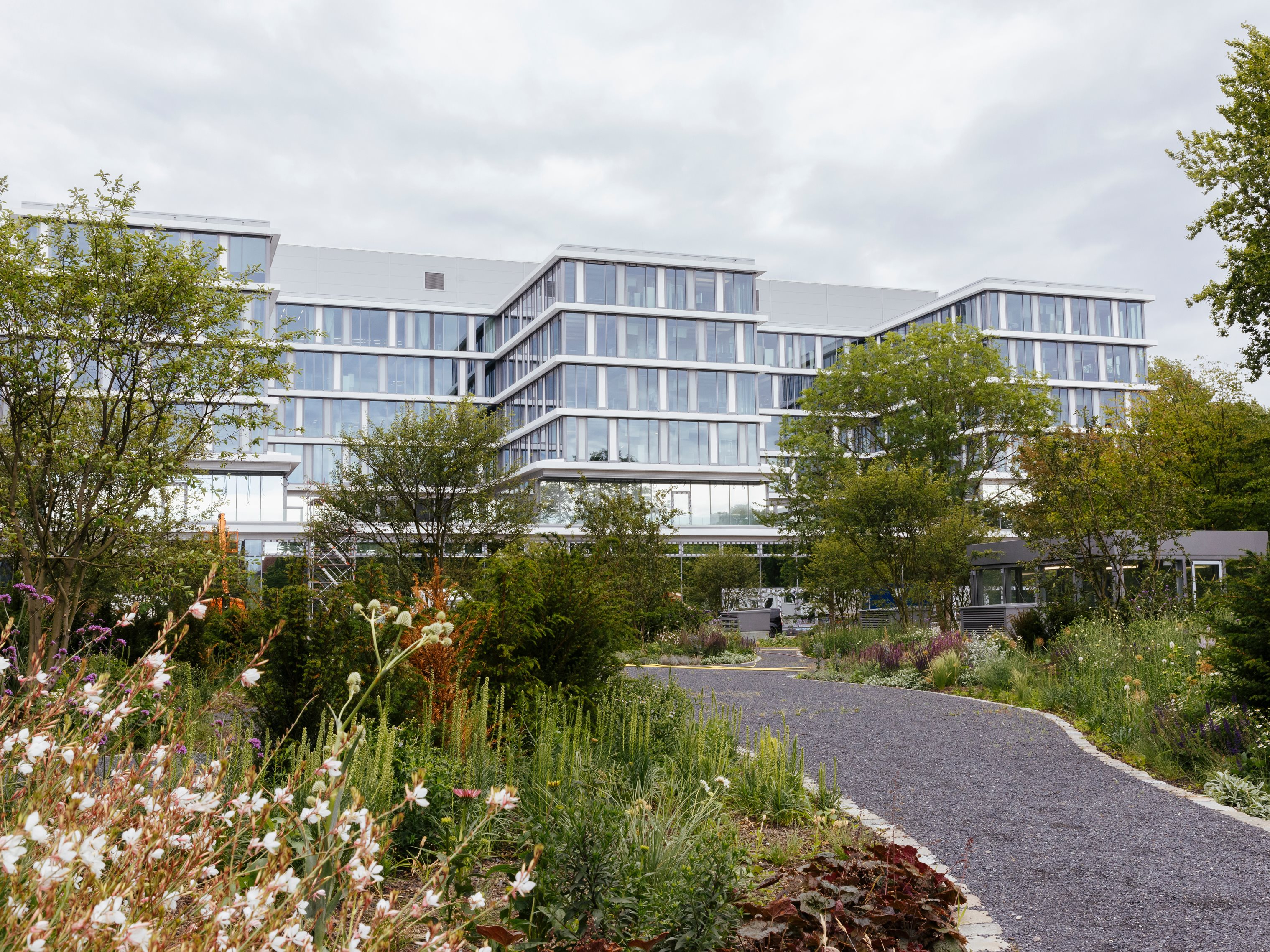 Grüner Garten mit modernem Bürogebäude im Hintergrund