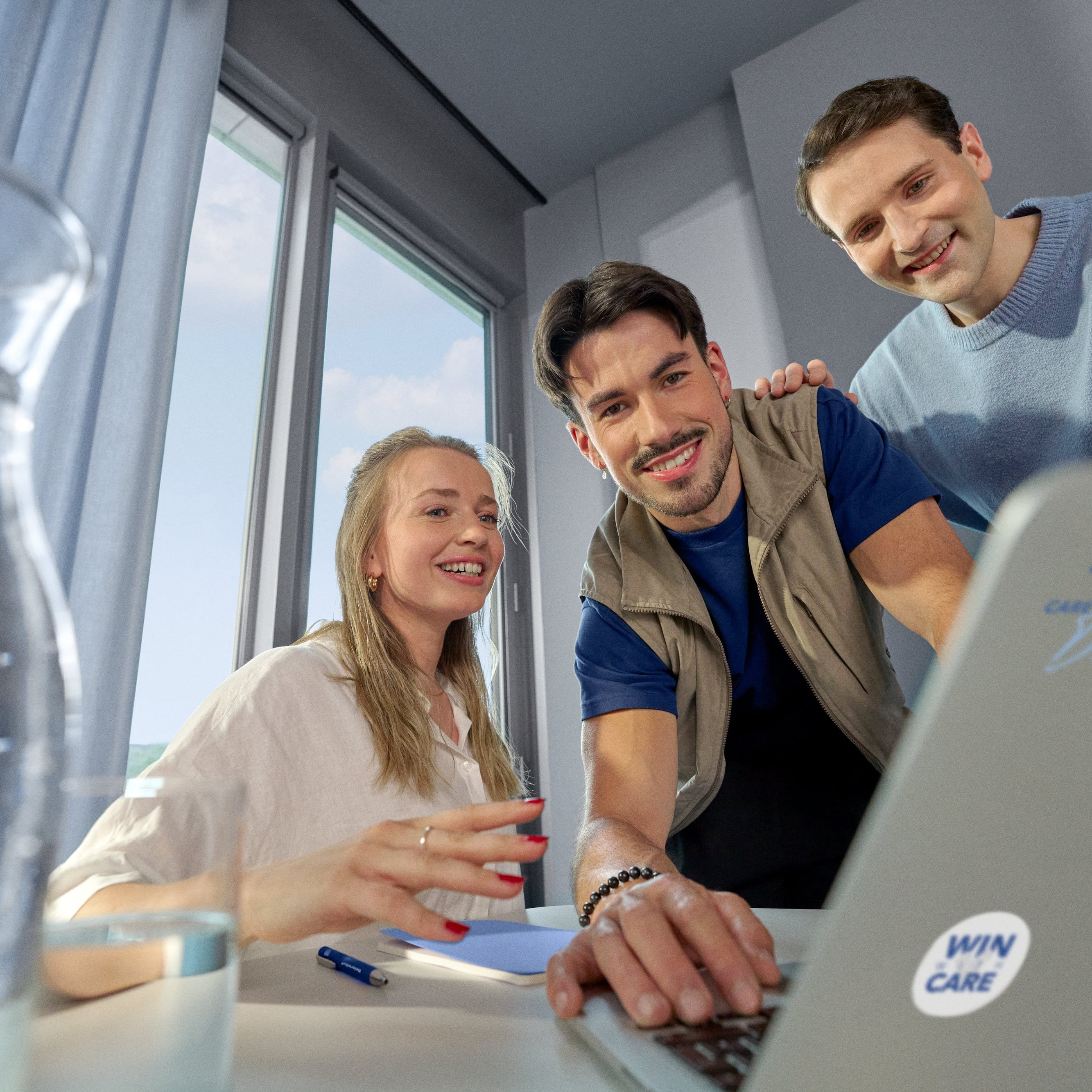 Beiersdorf Mitarbeitende besprechen Projektinhalte an einem Laptop und stehen für Zusammenarbeit, Innovation und Karrieremöglichkeiten in einem globalen Team.